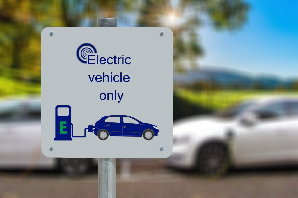 A sign in a parking lot indicating the spot is for electric vehicles and EV charging only