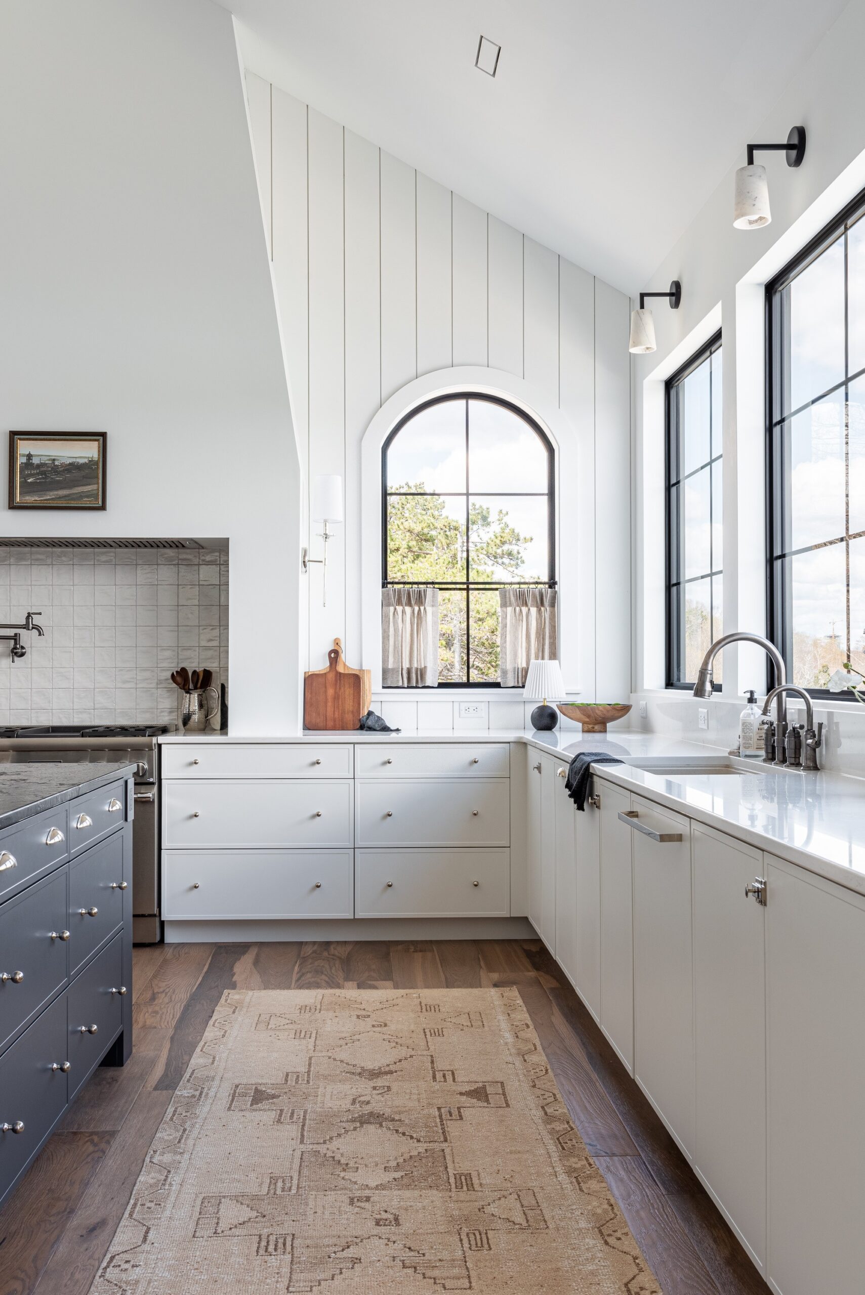 A view of the kitchen looking towards the encased range hood provides a spanish meets farmhouse vibe