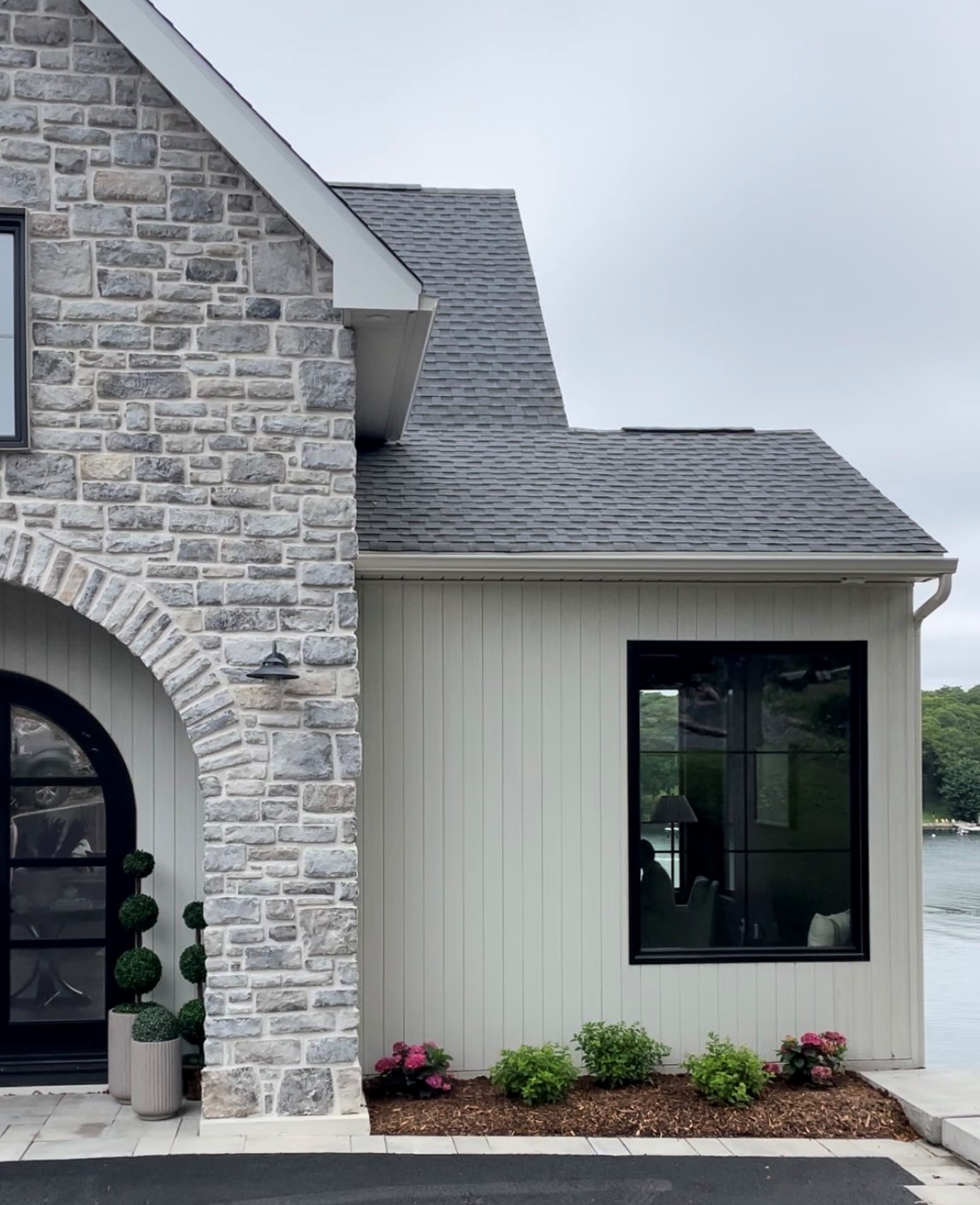 Hinkley Lighting's aged zinc finish Atwell outdoor sconces mounted on the welcoming stone arch add just the right touch of traditional industrial style
